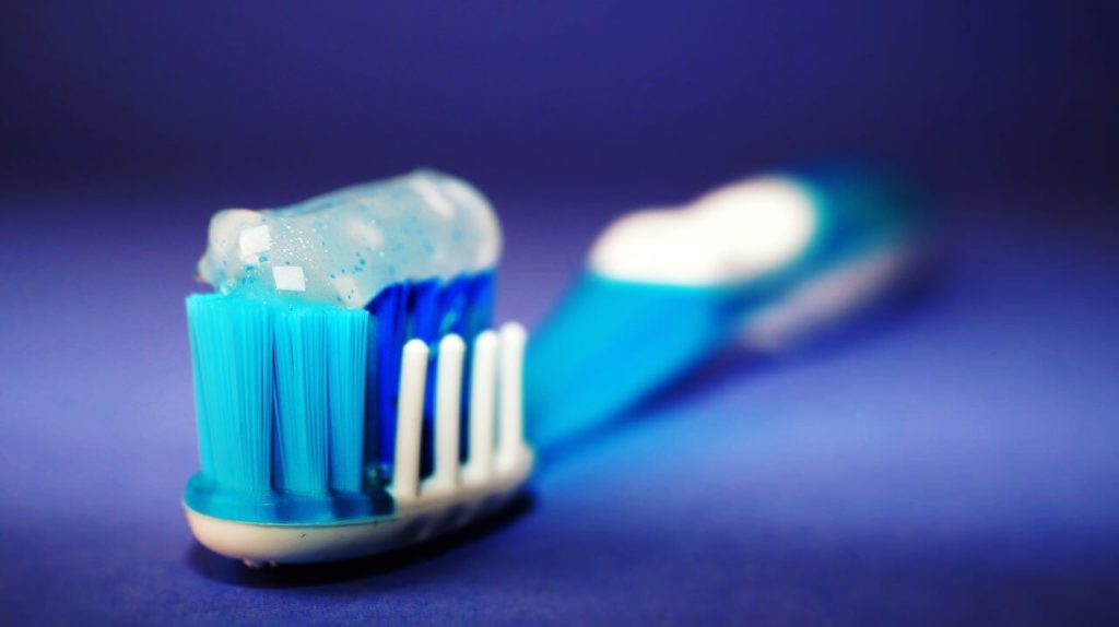 blue toothbrush with gel toothpaste on its bristles