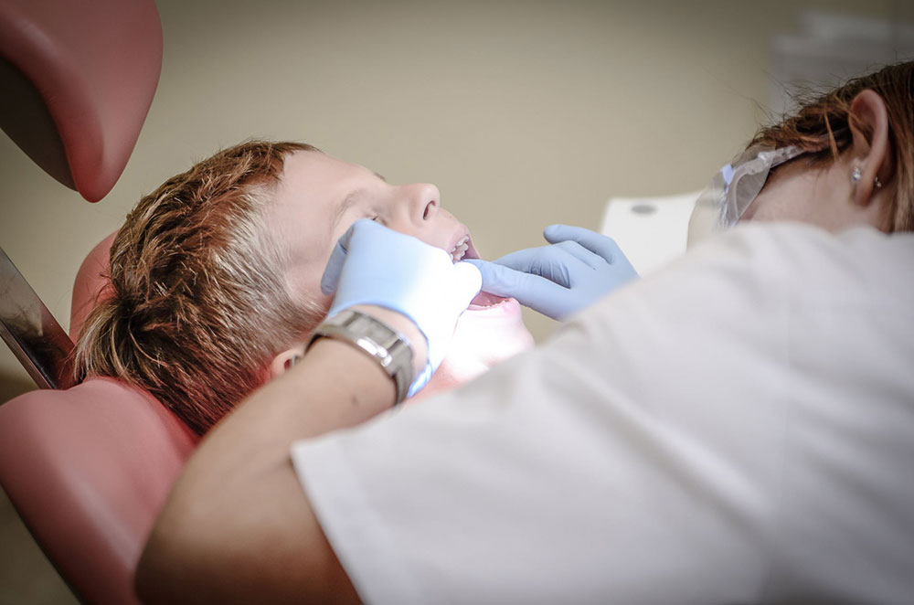 a dentist checking a patient's mouth for signs of gum disease