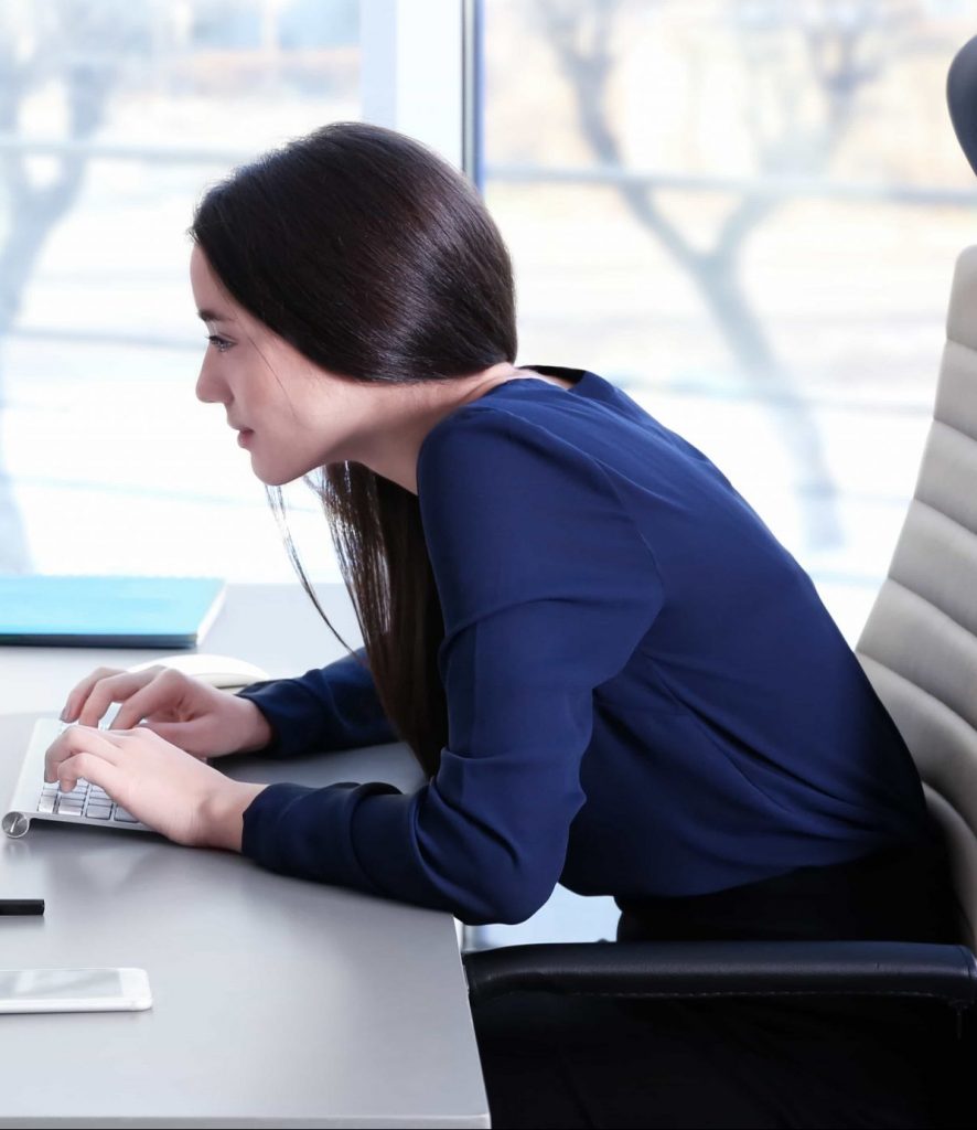 young woman hunched over work desk