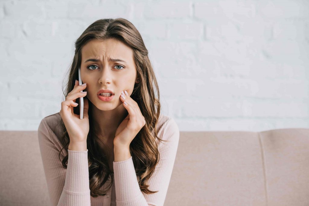 young woman on the phone with toothache