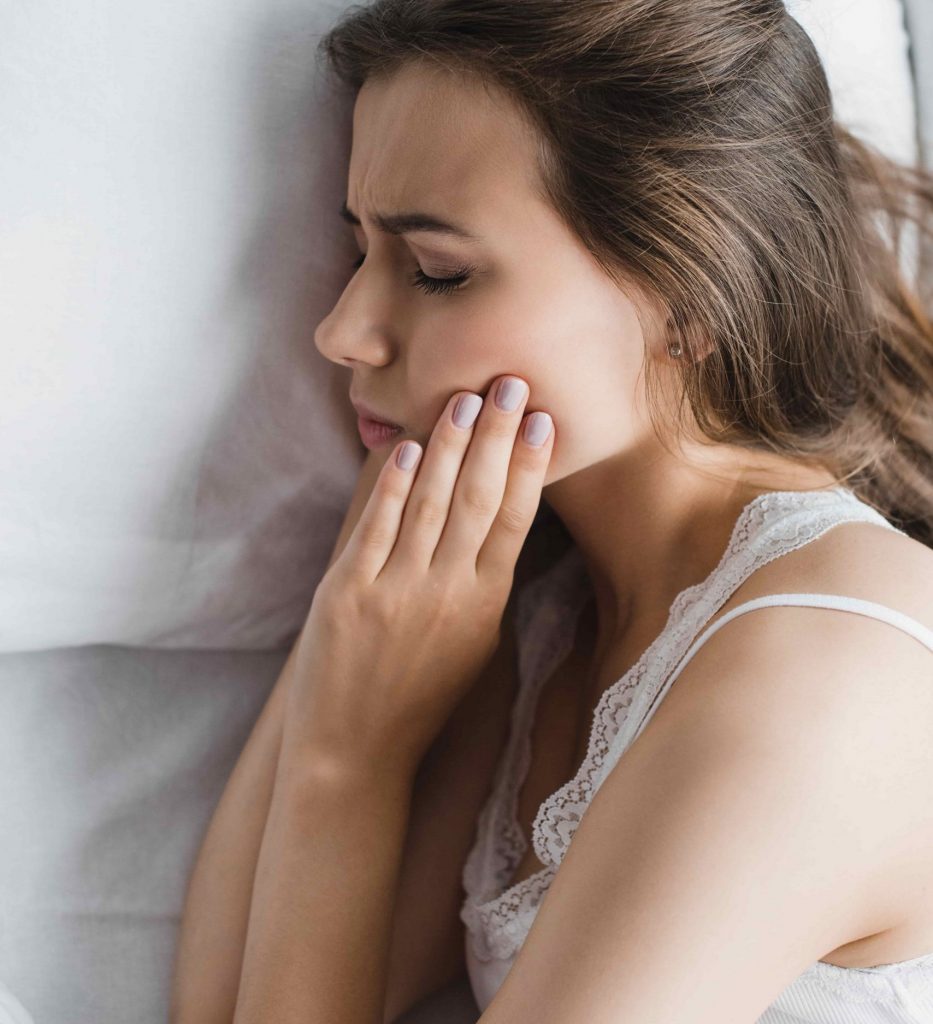 young woman suffering from tooth pain